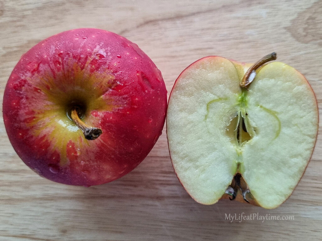 Apple cut into half to show what is inside.